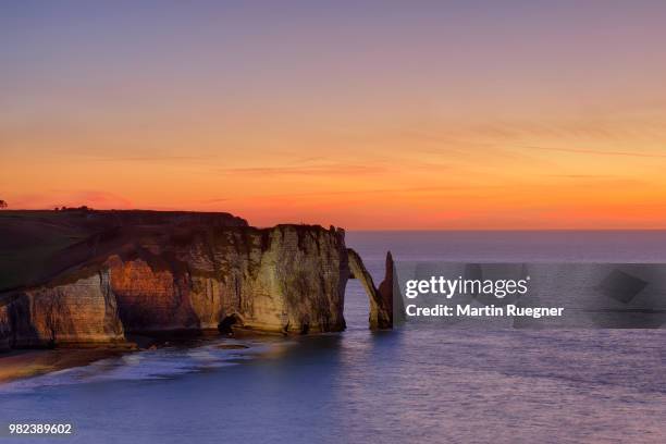 falaise d'aval, with aiguille rock formation and arch at sunset dawn. les falaises d'etretat, aiguille d'etretat, etretat, seine-maritime department, normandy, france - falaise normandie foto e immagini stock