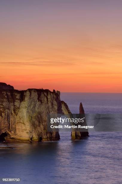 falaise d'aval, with aiguille rock formation and arch at sunset dawn. les falaises d'etretat, aiguille d'etretat, etretat, seine-maritime department, normandy, france - falaise normandie stock pictures, royalty-free photos & images