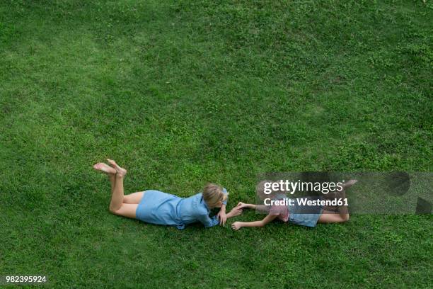 bird's eye view of mother and daughter talking to each other in garden - lying on front stock pictures, royalty-free photos & images