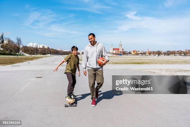 father and son with longboard and basketball outdoors - father longboard stock pictures, royalty-free photos & images