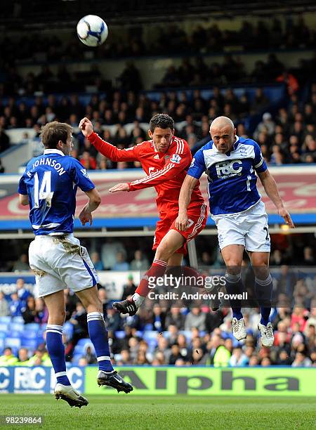Maxi Rodriguez of Liverpool goes up with Stephen Carr of Birmingham during the Barclays Premier League match between Birmingham City and Liverpool at...