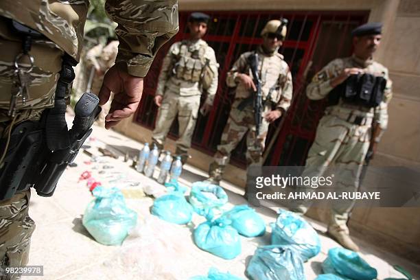 Iraqi soldiers display a weapons cache discovered inside a building in the Al-Jamia district of west Baghdad on April 4, 2010. Three suicide car...