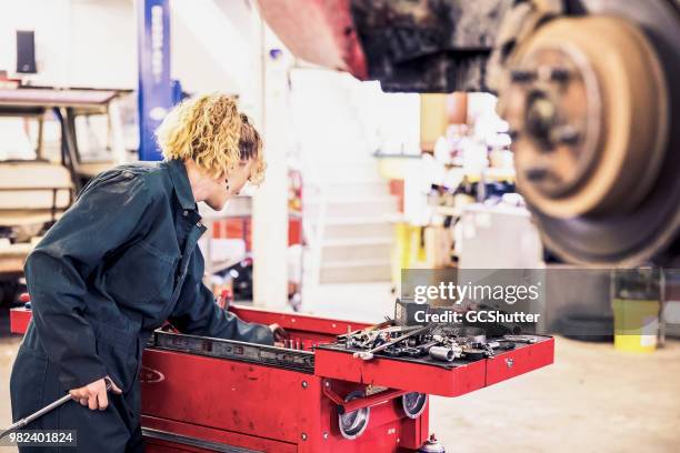female mechanic looking for a tool to service the car - brake pad stock pictures, royalty-free photos & images