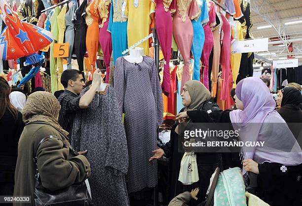 Women look at clothes during the annual meeting of French Muslims organized by the Union of Islamic Organisations of France in Le Bourget, outside...