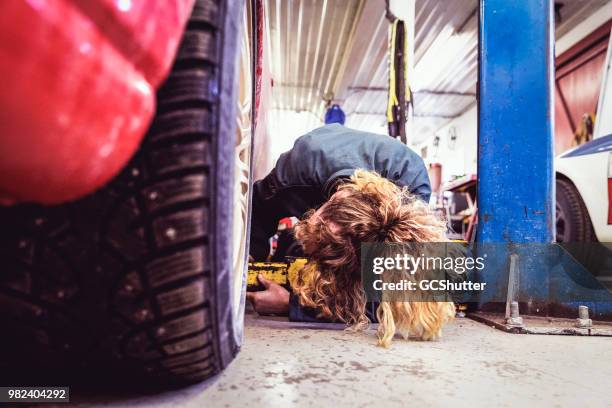 mujer mecánico de ajuste de la elevación del coche para la inspección - bloque de freno fotografías e imágenes de stock