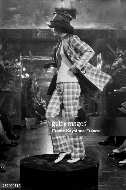 Mannequin présentant un modèle Ted Lapidus : un ensemble veste et pantalon à carreaux avec casquette, en France, le 4 mars 1969.