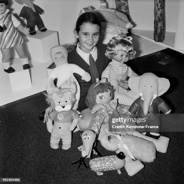 Enfant tenant de nombreux jouets, dont Babar, au 8ème salon international du jouet à la porte de Versailles à Paris en France, le 2 février 1969.