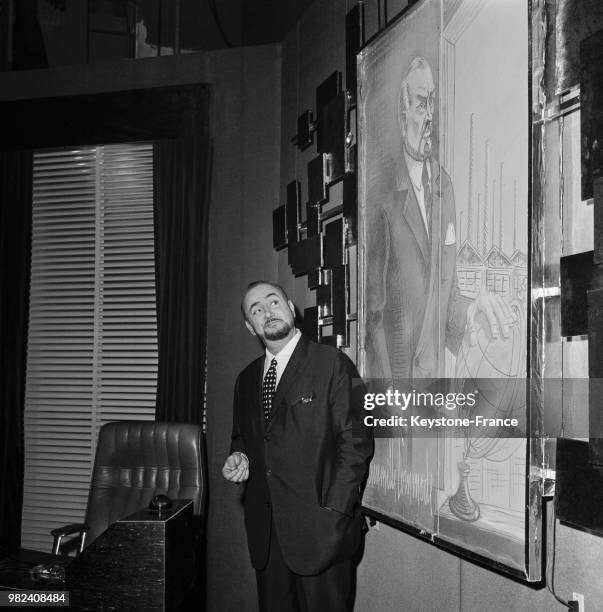 Portrait de Pierre Brasseur devant un tableau le représentant, circa 1969.