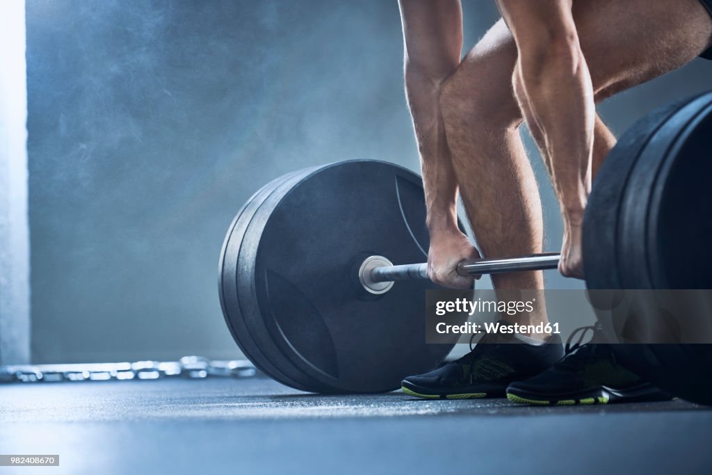 Close-up of man doing deadlift exercise at gym