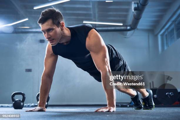 athletic man doing pushups exercise at gym - トレーニングウェア ストックフォトと画像