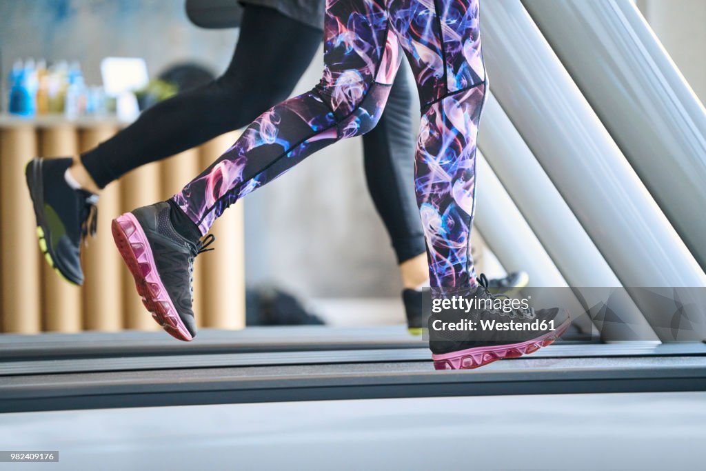 Close-up of people running on treadmill at gym