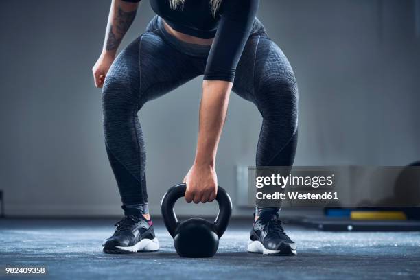 close-up of athletic woman exercising with kettlebell at gym - poids-et-haltères photos et images de collection