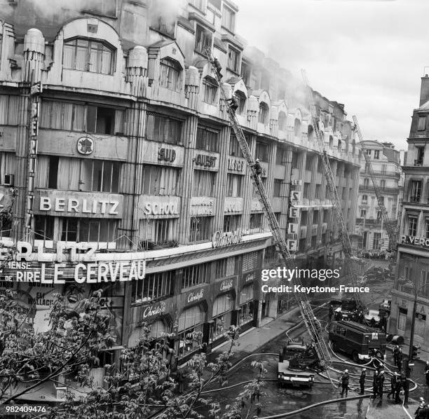 Les pompiers luttent contre l'incendie à l'école Berlitz à Paris en France, le 11 avril 1969.