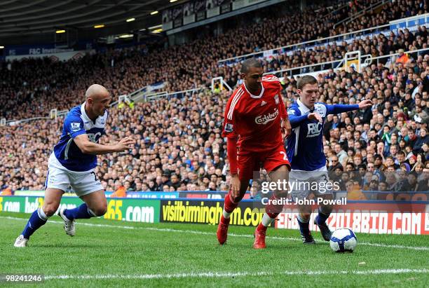 David Ngog of Liverpool competes with Craig Gardner of Birmingham during the Barclays Premier League match between Birmingham City and Liverpool at...