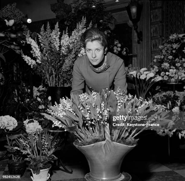 Caroline Cnocquaert devant un bouquet de muguet chez le fleuriste Lachaume à Paris en France, en mai 1969.