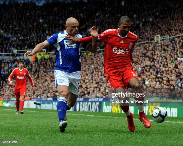 David Ngog of Liverpool competes with Stephen Carr of Birmingham during the Barclays Premier League match between Birmingham City and Liverpool at...