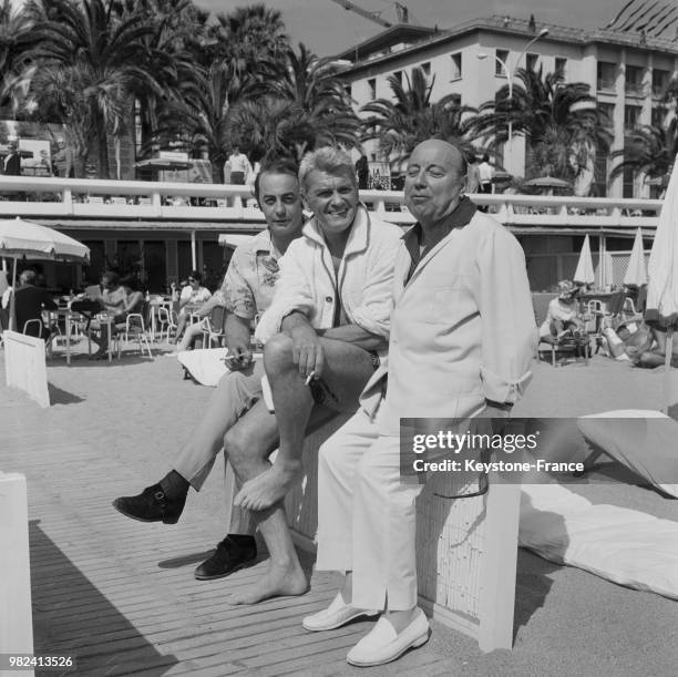 Roland Lesaffre, Jean Marais et Marcel Carné sur la plage lors du festival international du film à Cannes en France, le 16 mai 1969.