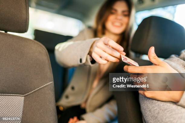 young businesswoman paying taxi, close-up - car money stock-fotos und bilder