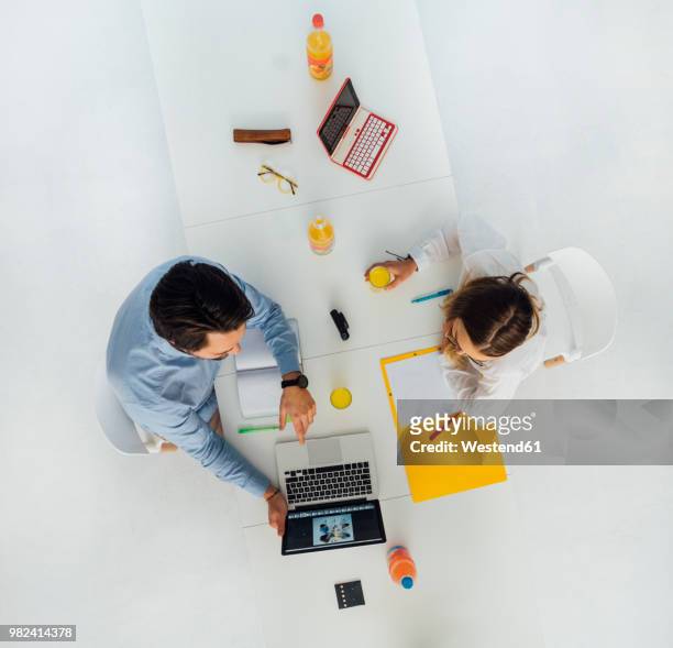 two business people at meeting table in office, top view - geschäftskleidung stock-fotos und bilder