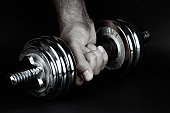 Hand holding a dumbbell in a fist