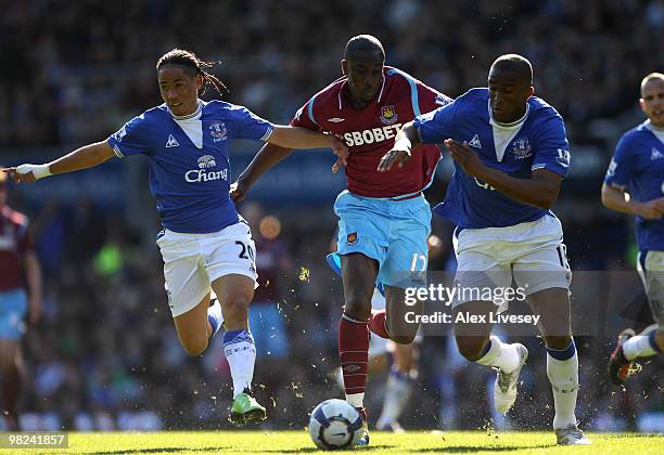 Steven Pienaar and Sylvain Distin of Everton battle for the ball with Carlton Cole of West Ham United during the Barclays Premier League match...