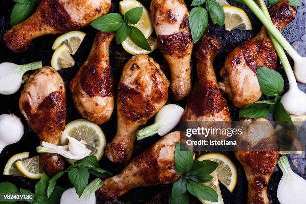 roasted chicken legs with vegetables and herbs on baking tray - pollo asado fotografías e imágenes de stock