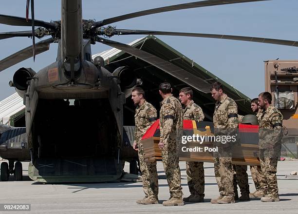 The coffin of a killed Bundeswehr soldier is loaded by German soldiers in the presence of German development minister Dirk Niebel at a ceremony in a...