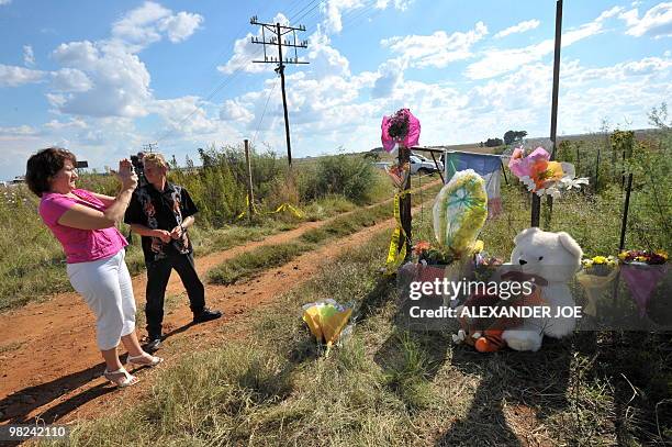 South African takes a picture of flowers on the fenceline of of farmer and far right-wing leader Euguene Terre'Blanche's property where he was killed...