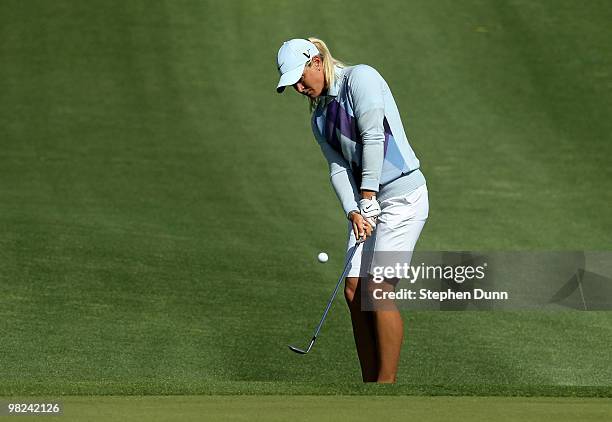 Suzann Pettersen of Norway chips onto the green on the second hole during the final round of the Kraft Nabisco Championship at Mission Hills Country...