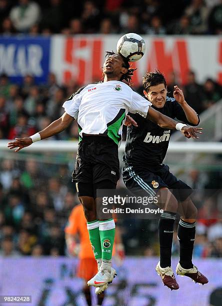 Fernando Gago of Real Madrid goes for a high ball against Mohammed Tchite of Racing Santander during the La Liga match between Racing Santander and...