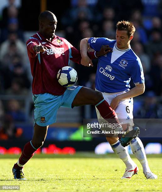 Carlton Cole of West Ham United tussles for posession with Phil Jagielka of Everton during the Barclays Premier League match between Everton and West...
