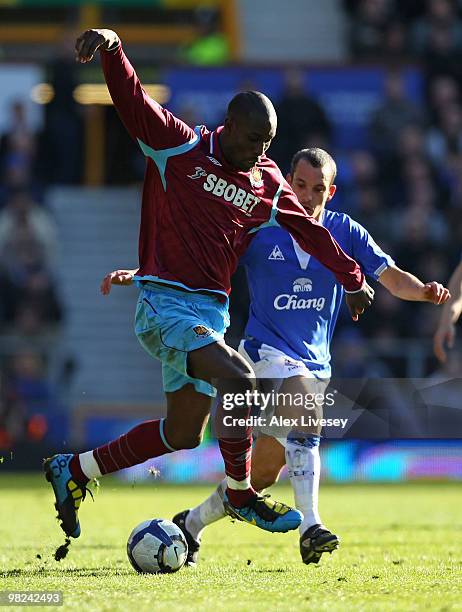 Carlton Cole of West Ham United competes for the ball with Leon Osman of Everton during the Barclays Premier League match between Everton and West...