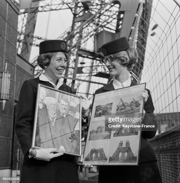 Deux hôtesses présentant l'une un portrait de Gustave Eiffel et l'autre les diverses étapes de construction de la tour Eiffel lors des 80 ans de la...