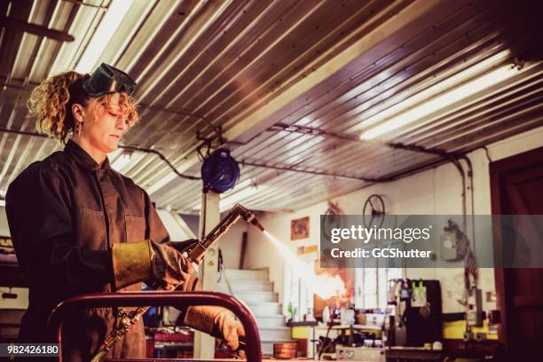 vrouwelijke automonteur houden de gas fakkel lassen - minimum wage stockfoto's en -beelden