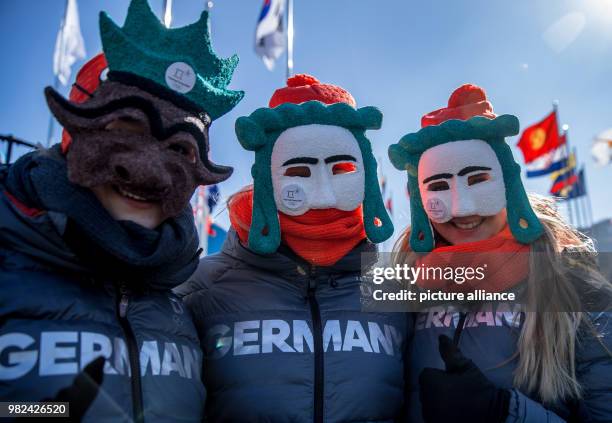 The German athletes Ann-Christin Strack, Anna Koehler and Lisa Buckwitz wear masks during the welcoming ceremony at the Olympic village in...