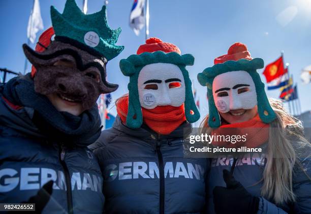 The German athletes Ann-Christin Strack, Anna Koehler and Lisa Buckwitz wear masks during the welcoming ceremony at the Olympic village in...