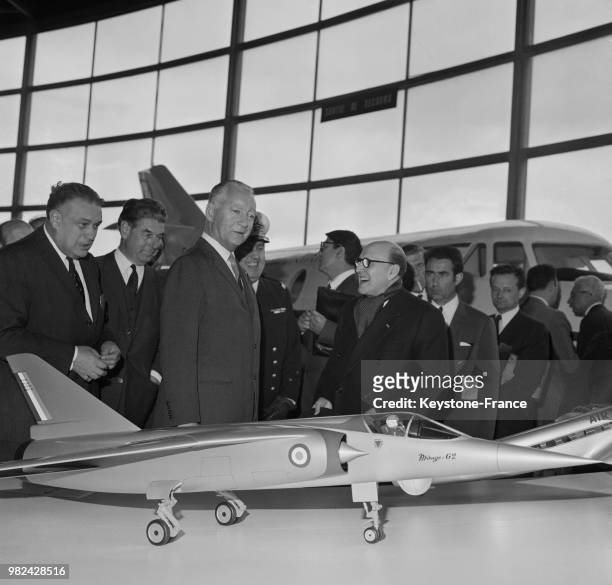 Le ministre des armées Pierre Messmer avec le constructeur Marcel Dassault devant un modèle de l'avion 'Mirage 64' lors de l'inauguration du salon...