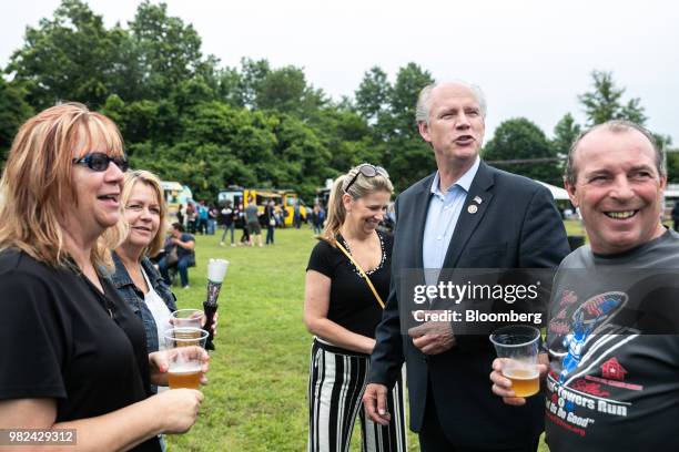 Representative Dan Donovan, a Republican from New York, second right, speaks with attendees during a campaign stop at the Mount Loretto Food Truck...