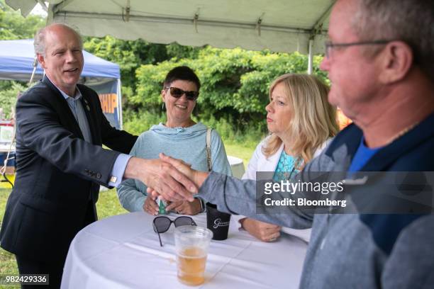 Representative Dan Donovan, a Republican from New York, left, greets attendees during a campaign stop at the Mount Loretto Food Truck Festival in the...