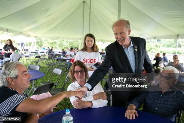 Representative Dan Donovan, a Republican from New York, second right, greets attendees during a campaign stop at the Mount Loretto Food Truck...