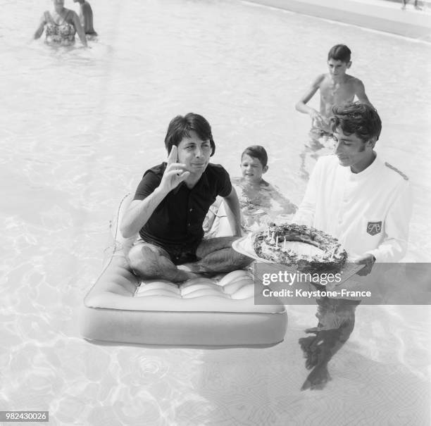 Hervé Vilard fêtant son anniversaire dans la piscine de l'hôtel Palm Beach à Cannes, dans les Alpes-Maritimes, le 30 juillet 1969, France.