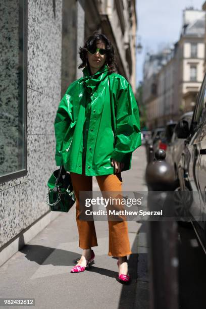 Guest is seen on the street during Paris Men's Fashion Week S/S 2019 wearing a green PVC coat with copper pants on June 23, 2018 in Paris, France.