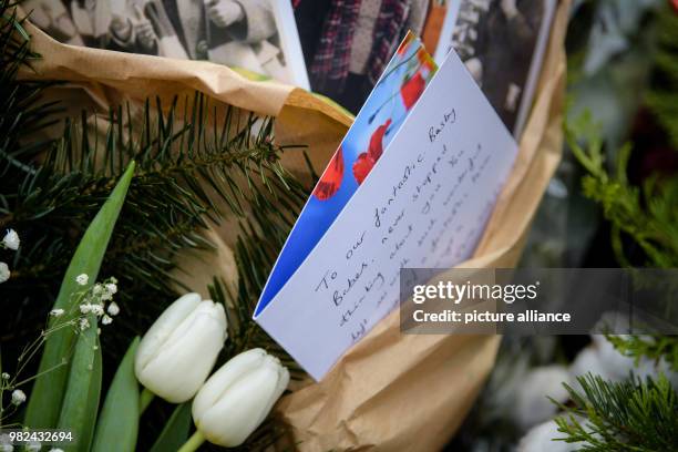 Card of mourning reading "To our fantastic Busby Babes" is placed beside flowers at a memorial service for the victims of the Manchester United air...