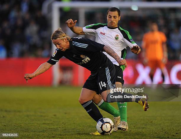 Guti of Real Madrid is tackled by Medhi Lacen of Racing Santander during the La Liga match between Racing Santander and Real Madrid at El Sardinero...