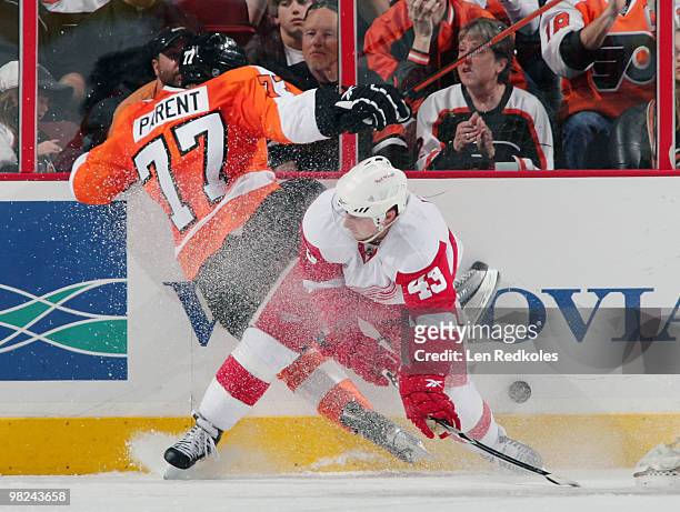 Ryan Parent of the Philadelphia Flyers is checked into the boards by Darren Helm of the Detroit Red Wings on April 4, 2010 at the Wachovia Center in...