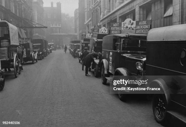 Voitures publicitaires attendant pour transporter les journaux dans Fleet Street à Londres en Angleterre au Royaume-Uni, en 1936.