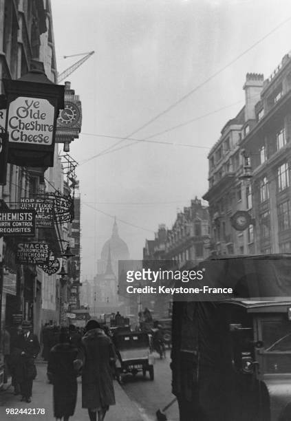 Vue de Fleet Street, avec notamment l'enseigne du pub 'Ye Olde Cheshire Cheese', à Londres en Angleterre au Royaume-Uni, en 1936.