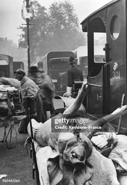 Marché de la viande dans le quartier de Smithfield carcasses de porcs empilées sur des charettes à Londres en Angleterre au Royaume-Uni, en 1936.