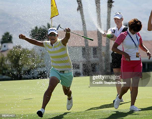 Champion Yani Tseng of Taiwan runs as Morgan Pressel sprays her with Champaign on the 18th green after the final round of the Kraft Nabisco...