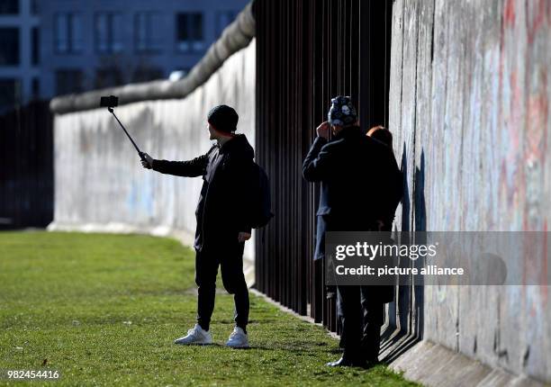 Dpatop - Tourists take pictures at the Berlin Wall memorial site in Berlin, Germany, 5 February 2018. The Berlin Wall stood for 28 years, two months...